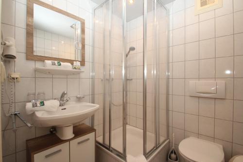 uma casa de banho com um chuveiro, um lavatório e um WC. em Hoarachhof em Innsbruck