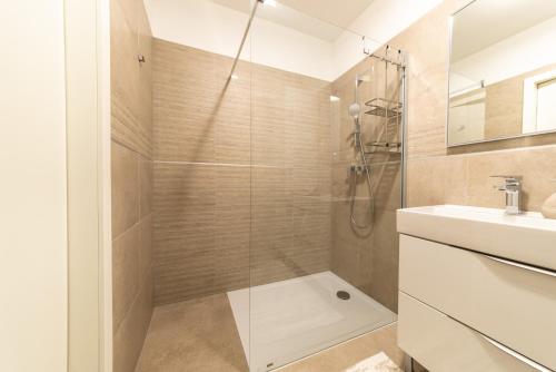 uma casa de banho com um chuveiro e um lavatório. em Apartment Bella em Zadar