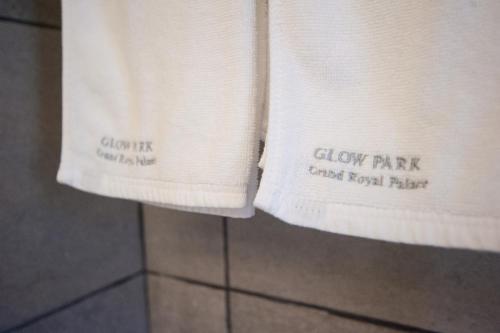 two white towels are hanging on a wall at GLOW PARK HOTEL Grand Royal Palace in Phnom Penh