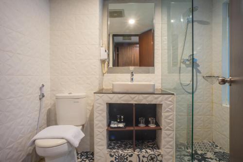 a bathroom with a toilet and a sink and a shower at Royal Regantris Cendana in Surabaya