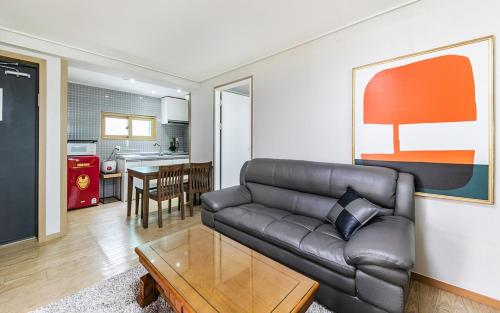 a living room with a leather couch and a table at YAJA Hotel Tongyeong Ferry Terminal Branch in Tongyeong