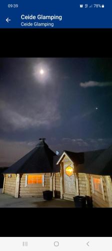 a picture of a house with the moon in the sky at Ceide Glamping in Ballycastle