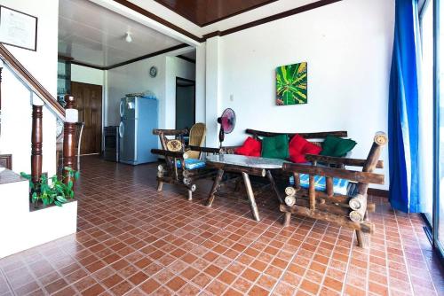 a living room with wooden furniture and a refrigerator at Charming 6-Bed House in Puerto Galera in Puerto Galera