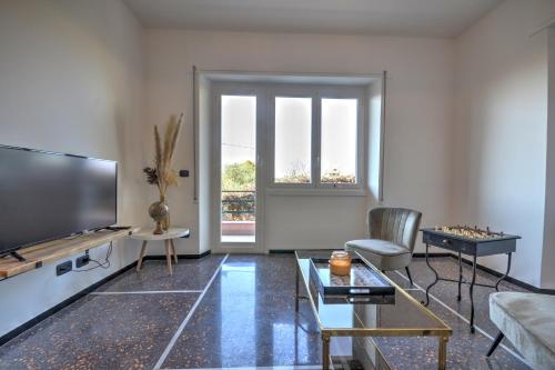 uma sala de estar com uma televisão de ecrã plano e um sofá em Cosy Home Riviera Wi-fi, AC, terrace 3 BDR em Chiavari