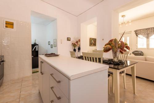 a kitchen and living room with a counter and a table at Gogo's Cosy Beach House in Rethymno