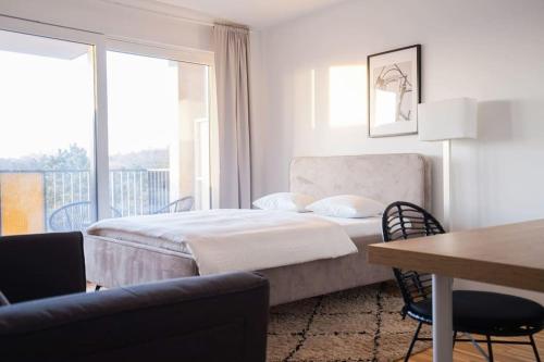 una camera con letto, tavolo e finestra di Fine Studio with terrace - 15 Min to Center a Vienna