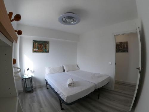 ein weißes Schlafzimmer mit einem Bett in einem Zimmer in der Unterkunft ROCH - Stylish Apartment near Metro in Sevilla