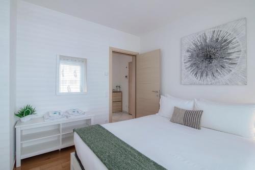 a white bedroom with a bed and a window at Il Parco 7 by Quokka 360 - in the business centre of Lugano in Lugano