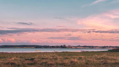 a beach with a body of water and a cloudy sky at Hørby Færgekro in Holbæk