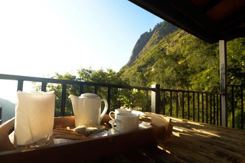 a table with two cups and towels on a balcony at Ella Camelot in Ella