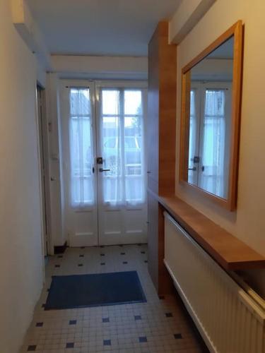 un couloir avec un miroir et une porte avec une fenêtre dans l'établissement Vacances à la Tranche sur Mer, à La Tranche-sur-Mer