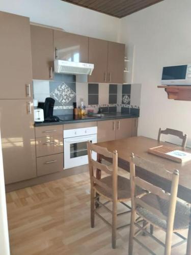 une cuisine avec une table en bois et une table et des chaises dans l'établissement Vacances à la Tranche sur Mer, à La Tranche-sur-Mer