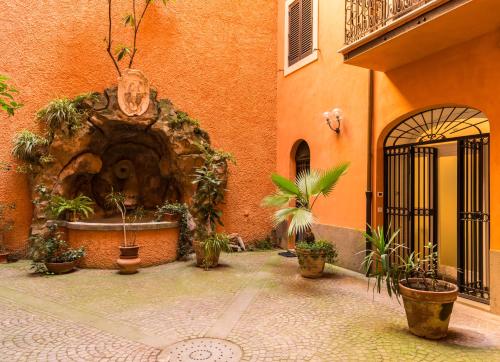 a courtyard with a fountain in a building with potted plants at Martina al Colosseo in Rome