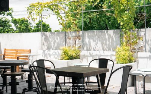 - un ensemble de tables et de chaises sur une terrasse dans l'établissement de'Govin Hotel, à Tjakranegara