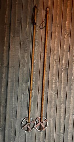 two hockey sticks are sitting on a wooden floor at Porthos Ski-in Lodge with private hot tub and sauna in Lapland in Pyhätunturi