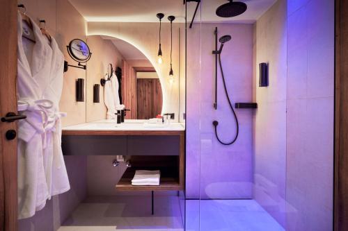 a purple bathroom with a sink and a shower at Hotel Edenlehen in Mayrhofen