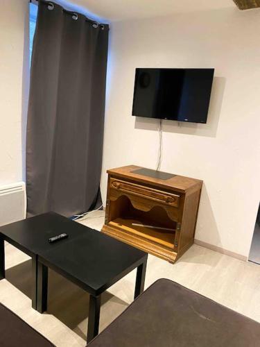 un salon avec une télévision à écran plat sur un mur dans l'établissement Appartement Essentiel, à Givet