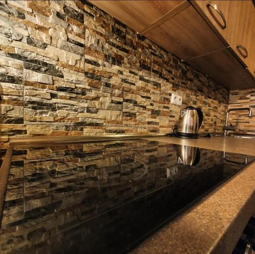 a kitchen with a counter with a stone wall at Mysterylodge Bjelašnica Treskavica in Sarajevo