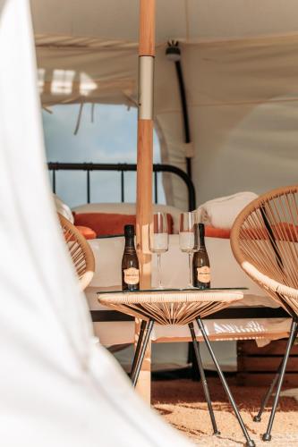 a table and chairs with wine glasses on it at Bamburgh Under Canvas in Bamburgh
