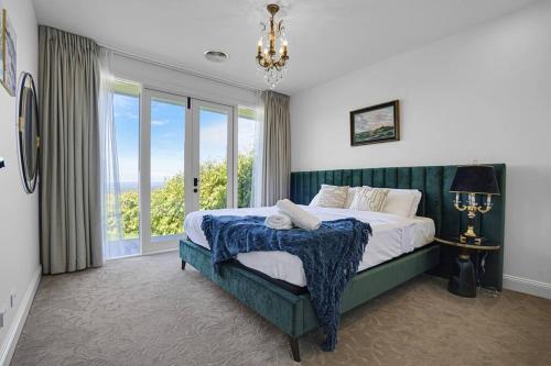 ein Schlafzimmer mit einem Bett und einem großen Fenster in der Unterkunft Luxury & plush lifestyle 5 Bedroom house in Mt Eliza in Mount Eliza