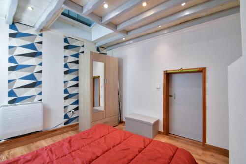 um quarto com uma cama vermelha e uma parede azul e branca em Les Herbages em Mers-les-Bains