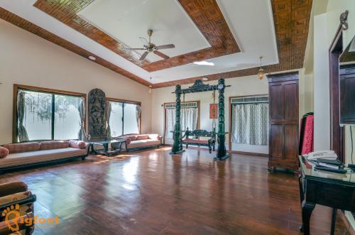 Ekayana Resorts and Agri Tourism, Mulshi في بيون: غرفة معيشة كبيرة مع أرضية خشبية وسقف