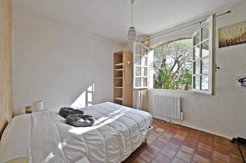 une chambre avec un lit et une grande fenêtre dans l'établissement Mas Demoiselle - Charmante maison 6 personnes, à Tornac