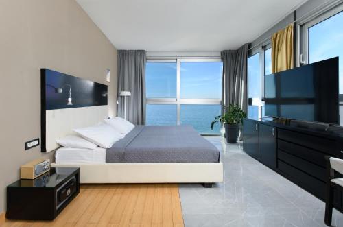 a bedroom with a bed with a view of the ocean at Hotel San Antonio in Podstrana
