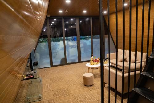 a room with a balcony with a chair and a table at Sunny Garden Riverside Hotel Ninh Binh in Ninh Binh