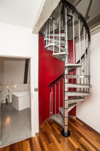 a spiral staircase in a room with a red wall at Fleischhauerhof in Lübeck