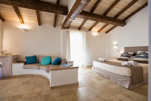 a bedroom with a bed and a couch at Villa Nicoletta in Santa Teresa Gallura