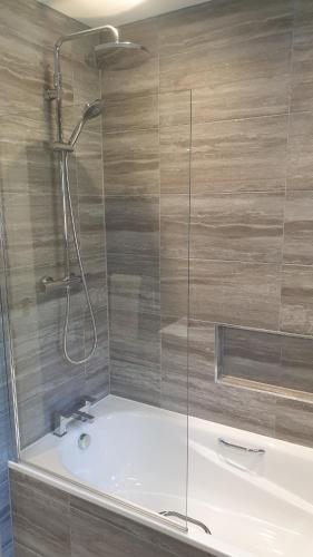 baño con ducha y puerta de cristal en Large modern self contained apartment in Lymington, en Lymington