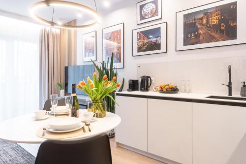 uma cozinha com uma mesa e um balcão branco em Manufaktura Modern Industrial Apartment em Lódź