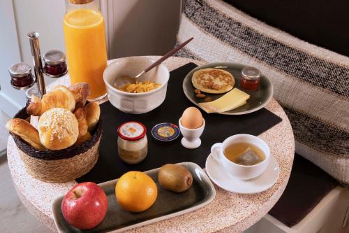 a breakfast tray with breakfast foods on a table at Le Petit Oberkampf Hotel & Spa in Paris