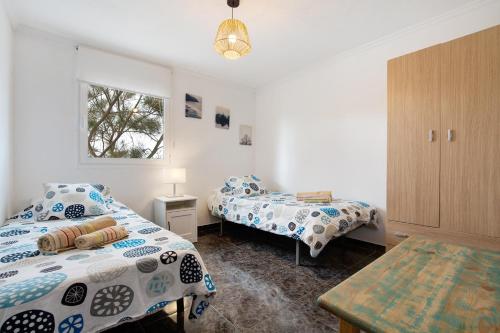 a bedroom with two beds and a window at El Cotillo Mar Beach in El Cotillo