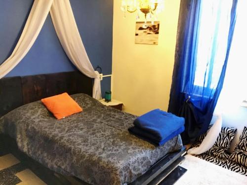 a bedroom with a bed with blue and orange pillows at Accogliente appartamento in centro in Frabosa Soprana