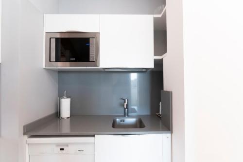 a kitchen with a sink and a microwave at Mansarda Cola in Milan