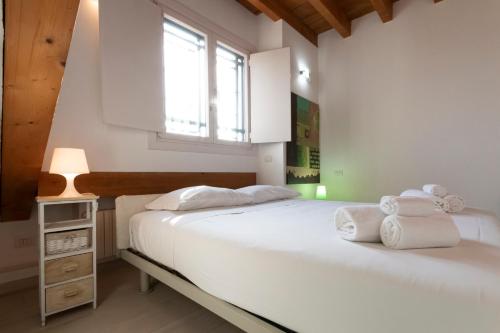 two beds in a white room with a window at Mansarda Cola in Milan