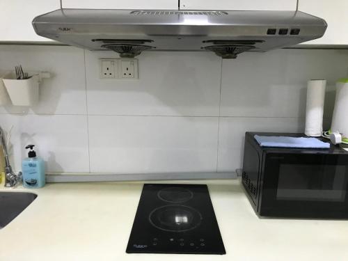 un forno a microonde seduto sopra un bancone della cucina di SHAH ALAM BUKIT JELUTONG NUR HOMME a Shah Alam