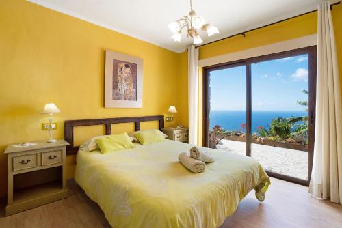 a bedroom with a bed with a view of the ocean at Casita Paraiso in Los Quemados