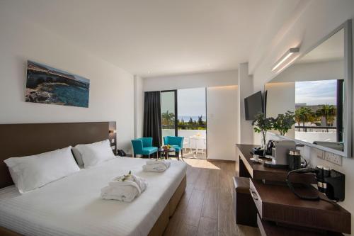 a hotel room with a bed and a desk with a television at Christofinia Hotel in Ayia Napa