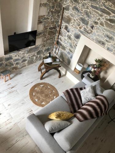 a living room with a couch and a stone wall at U Vechju Fragnu in Vezzani