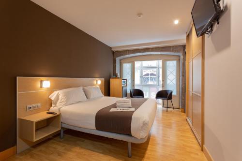 a hotel room with a bed and a television at Casual Arriaga in Bilbao