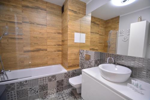 bagno con lavandino, vasca e servizi igienici di Apartamenty Bryza-Ułańska 1A12 a Świnoujście