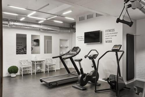 a gym with two exercise bikes and a flat screen tv at Hypernym Hotel & Suites in Copenhagen