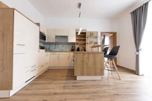 a kitchen with white cabinets and a wooden island at Landhofmühle in Eltendorf