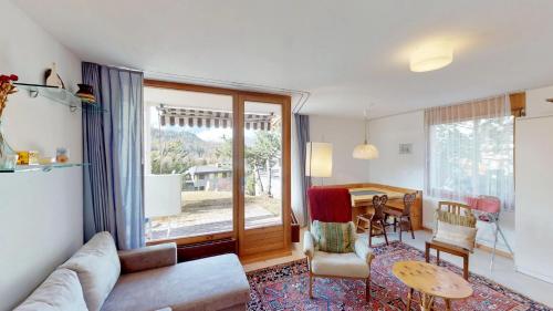 een woonkamer met een bank en een tafel bij Apartment Piz Cotschen B in Pontresina