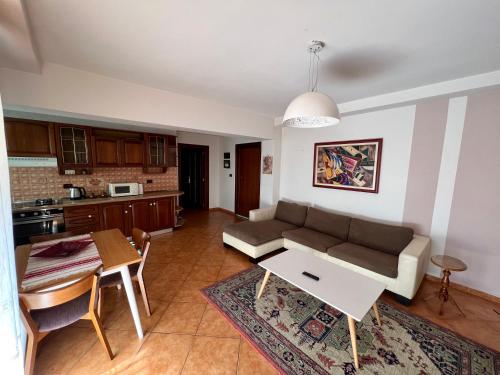 een woonkamer met een bank en een tafel bij Apartment in Skanderbeg Square - Tirana Center 1 in Tirana