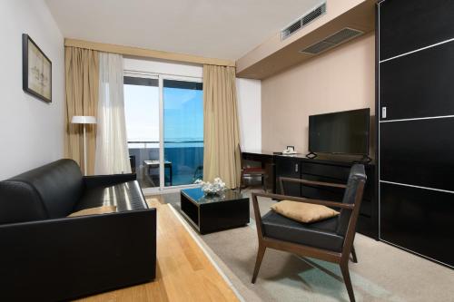 a living room with a couch and a television at Hotel San Antonio in Podstrana