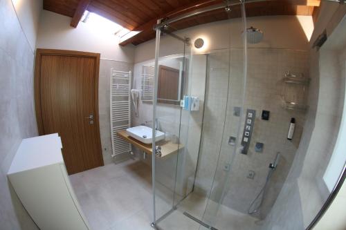 a bathroom with a glass shower and a sink at Mirko's house in Licata